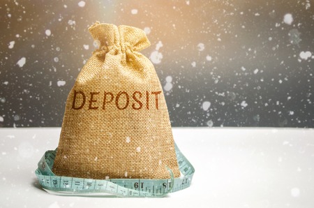 Bag with money and tape measure and the word deposit. The concept of the New Year's deposit. New Year's interest rates. Stocks Convenient and profitable offers. Christmas and seasonal deposits in bankの写真素材