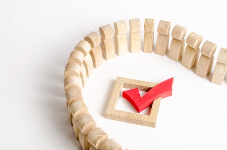 A queue of people and a red check mark on a white background. Democracy and legitimacy. The concept of elections and important decisions, a referendum, a poll, a social canon and a norm, traditions.の写真素材