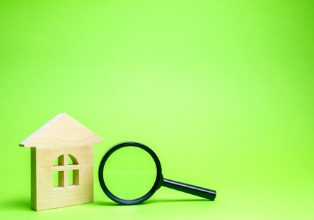 Wooden house and magnifying glass. Property valuation. Choice of location for the construction. House searching concept. Search for housing and apartments. Real estate concept. Home appraisalの写真素材