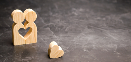A miniature couple in love and a heart near them. The concept of family problems and loss of feelings for your loved one. Consultation family psychologist. Rupture / divorce. Selective focusの写真素材