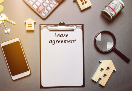 Table with wooden houses. Real estate. Lease agreement is a contract between a lessor and a lessee that allow lessee rights to use of a property owned by lessor. House or apartment rental conceptの写真素材