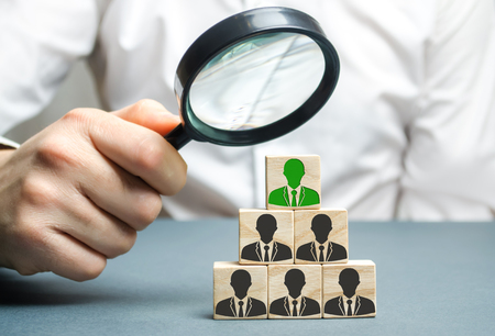 Find a talented employee. Businessman searching for new employees. Staff recruitment. Select a person in the team. Attracting people to work. Human Resource Management. Recruiting. Magnifying glassの写真素材
