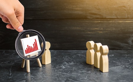 Magnifying glass is looking at the people gathered for a meeting or speech of the leader. Profit and income analysis, briefing and business webinar. Report. strategy planning. Selective focus.の写真素材
