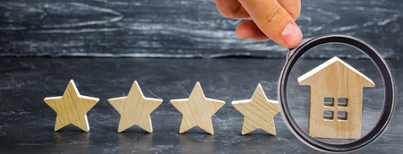 Five stars and a wooden house on a gray concrete background. The concept of the best housing, luxury apartments VIP class. The best service and universal recognition, a high score. Success.の写真素材