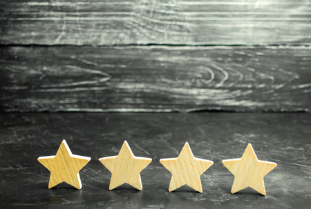 Four wooden stars. The concept of rating and evaluation. The rating of the hotel, restaurant, mobile application. Quality service, buyer choice. Success in business. selective focusの写真素材