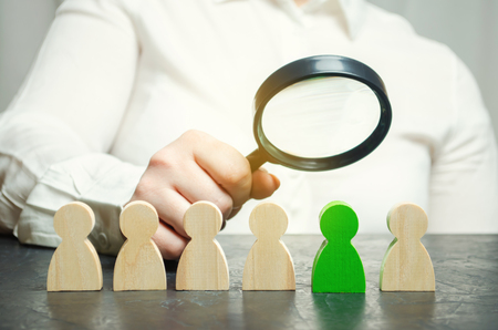 Businesswoman searching for new employees. Staff recruitment. Select a person in the team. Find a talented employee. Attracting people to work. Human Resource Management. Recruiting. Magnifying glassの写真素材