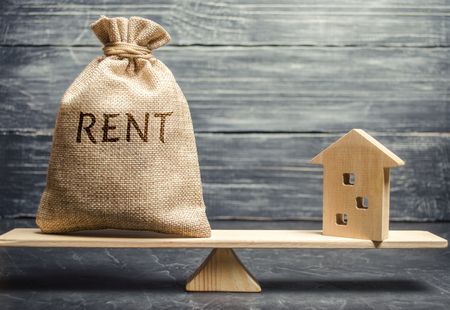 Money bag with the word Rent and a wooden house on the scales. The concept of payment for rental housing. Debt repayment. To renting a house. Rent a property. Court, Law and Justiceの写真素材