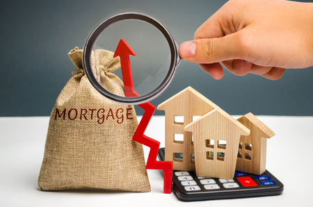 A bag with money and the inscription Mortgage and up arrow. Raising mortgage rates and tax. The increase in interest charges. Loan for housing, apartment and property. Increased demand for mortgagesの写真素材