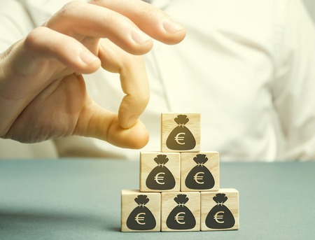 Businessman removes the cube with the image of the euro. Capital outflow. Pressure on small...