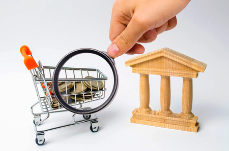 bank and the trolley with money. The concept of dividend payments, deposits in banks. Banking system, investment in the economy. Refusal of small denominations, devaluation. Profit growthの写真素材