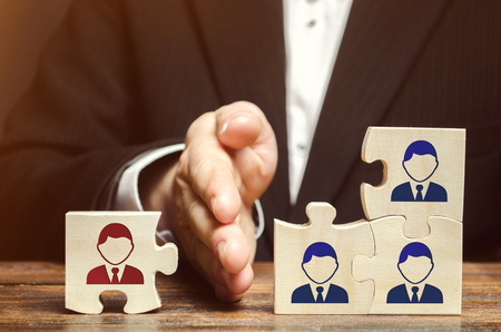 The leader separates the puzzle with the image of the employee. The concept of personnel management in the company. Dismissing an employees from a team. Demotion. Bad worker. Staff cutsの写真素材