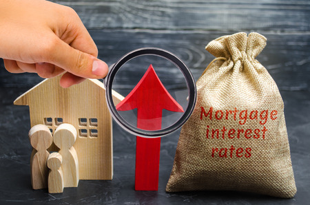 Bag with the money and the word Mortgage interest rates and up arrow with family and home. Raising...