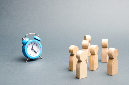 A crowd of people looks at the clock. Attention people are chained to the clock. Waiting for events over time. Relocation hours. Work day and hourly pay. Limited offer, time limit. Selective focusの写真素材