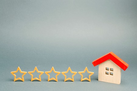 Five stars and a wooden house on a gray background. The concept of the best housing, luxury apartments VIP class. The best service and universal recognition, a high evaluation. Success. Feedbackの写真素材