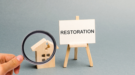 A poster with the inscription Restoration and a broken wooden house. Repair secondary housing. The...