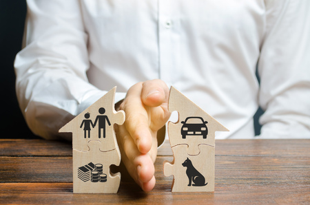 A man shares a house with his palm with images of property, children and pets. Divorce concept,...
