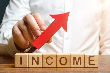 A man holds a red arrow over the words profit. Development of approaches and optimization of business processes to improve efficiency and profitability. Cost reduction, Financial advisorの写真素材