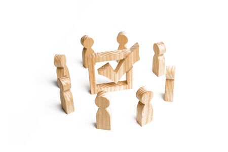 People stand in a circle and look at the check mark in the box. election, poll or referendum. Poll people. Voters participate in elections of parliament or president, teamwork. Selective focusの写真素材