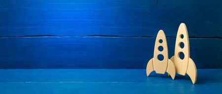 Wooden space rocket on a blue background. The concept of minimalism, high technologies and aspirations to conquer outer space. Business start-up. Education. copy space bannerの写真素材