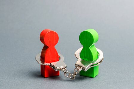 Two people are handcuffed to each other. Unclosed obligations between two persons, financial or moral debt. Contract, duty, responsibility and duty. Keep the word, keep the promise.の写真素材