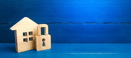 Wooden house with a padlock. House with a lock. Security and safety, collateral, loan for a mortgage. Confiscation of property for debts. Safety and alarm system. Buying a home. banner, place for textの写真素材