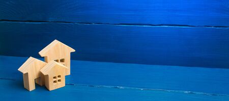 Buying and selling of real estate, construction. Three houses on a blue background. Apartments and apartments. City, settlement. Minimalism. presentations. real estate market. banner, place for textの写真素材