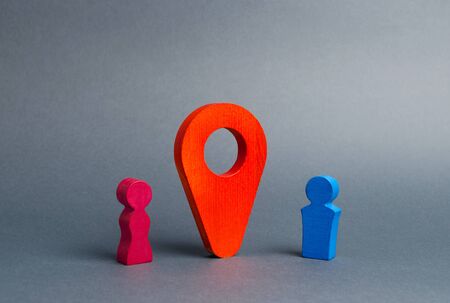 The guy and the girl met at the venue. Red marker location between them. Choosing a place for an interesting date. Search for restaurants and entertainment facilities. Search for love online.の写真素材