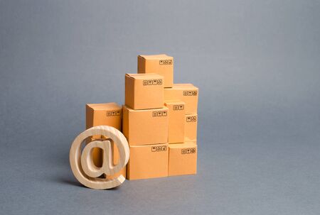 stack of cardboard boxes and email symbol commercial AT. E-commerce. sales of goods through online trading platforms. shopping online. development of Internet network trade, advertising services.の写真素材