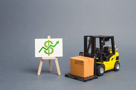 forklift truck carries a cardboard box and a stand with a green arrow up. Profit growth from sales and high production of goods. Retail, resale, sales of products. Added value of goods, modernizationの写真素材