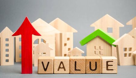 Wooden blocks with the word Value, up arrow and wooden houses. The concept of raising property prices. High cost for rental housing and real estate. Expensive loans to buy an apartment. Analyticsの写真素材