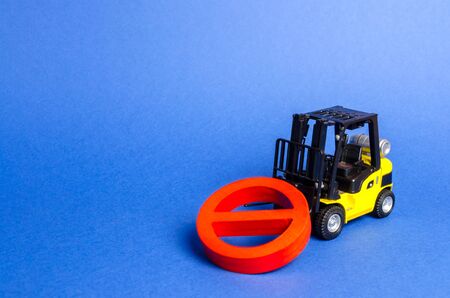 A yellow forklift truck cannot lift a red NO symbol. The concept of prohibition, sanctions and restrictions. Overcoming, bypassing difficulties. solving complex engineering and technical problemsの写真素材