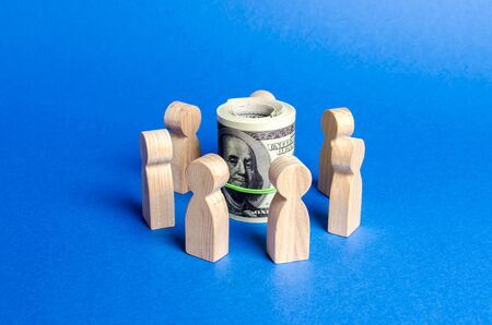 Figures of people surround a bundle of money. Concept of raising money for a startup or idea, crowdfunding. The adoption of budget money by contractors, corruption schemes. Financial investment groupsの写真素材