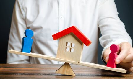 Man promotes female figures outweigh the balance of the scales in her favor. The separation of property and real estate after a divorce, lawyer services. trial of ownership of the house, illegal ownerの写真素材