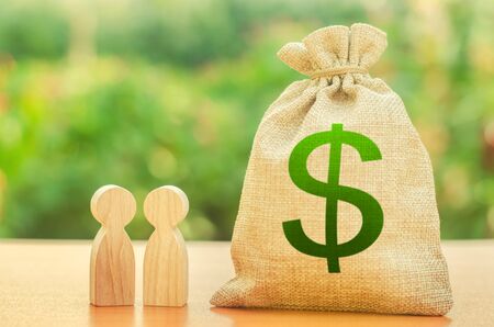 Money bag with dollar symbol and two people figures. Investment and lending, leasing. Business dispute and its solution between two businessmen. Available loans and subsidies, government supportの写真素材