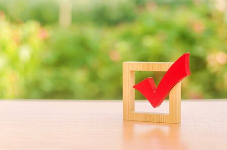 Red wooden checkmark for voting on elections. Presidency or parliamentary elections, a referendum. Survey of the population, statistics, task. Democracy and freedom. Life plans and goals. To do listの写真素材