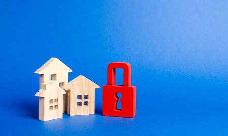 Three houses and a red padlock. Unavailable and expensive real estate. house Insurance. Security and safety. Confiscation for debts. alarm system. seizure of property. Protection of property rights.の写真素材