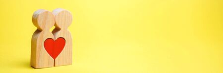 A couple in love and a heart between them. The concept of love and sympathy between two people. Meeting the love of all life. Human happiness. Dating. Declaration of Love. Valentine's Day. Minimalismの写真素材