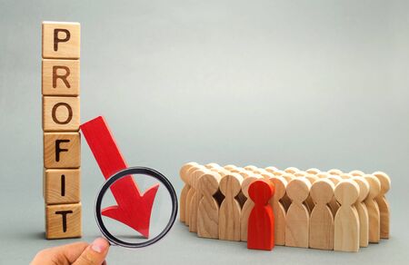 Wooden blocks with the word Profit, down arrow and business team. Unsuccessful business and bankruptcy. Profit decline. Loss of investment. Economic crisis. The fall of the financial market. Recessionの写真素材