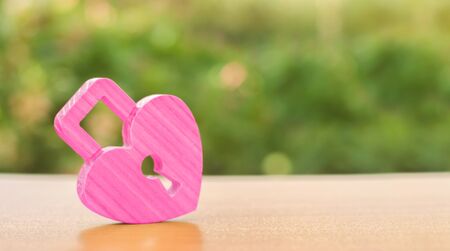 A pink padlock in shape of a heart. Heart health. The secret of relationships and the rules of a strong family. Strong love affair. Secrets, rumors and gossip. The concept of female intimate health.の写真素材