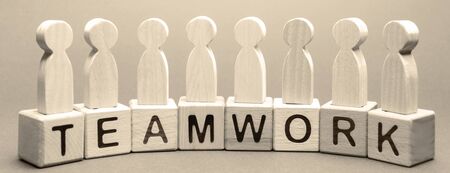 Wooden blocks with the word Teamwork and business team of employees. The concept of cooperation. Constructive feedback. Joint achievement of a common goal. High efficiency and performanceの写真素材