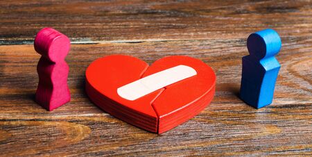 A red heart with a plaster and couple in lovers. Renewal of the relationship. Family psychotherapist...