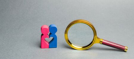 Couple of lovers standing near a magnifying glass. The concept of finding love and dating through...