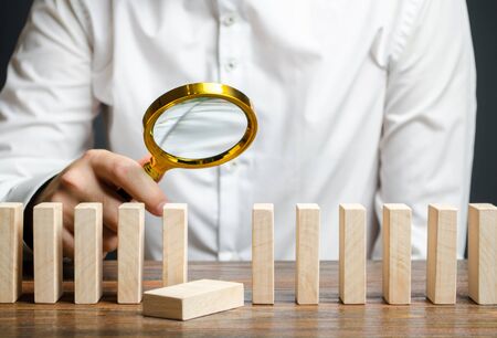 The wooden block fell out of order. The study of business mistakes. Weak link. Unreliable and unsuccessful plan. Risk assessment and strategy creation. Costs and ineffective management. Businessmanの写真素材