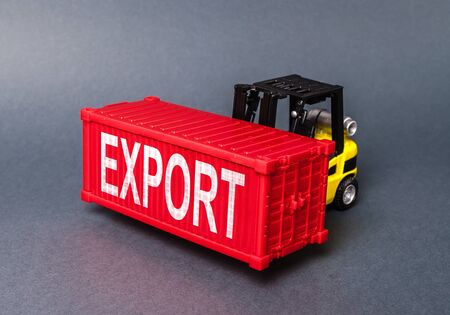 A forklift carries a red freight container labeled Export. concept transportation of goods and products, delivery, shipping. Industry and production, trade balance and distribution. Globalizationの写真素材