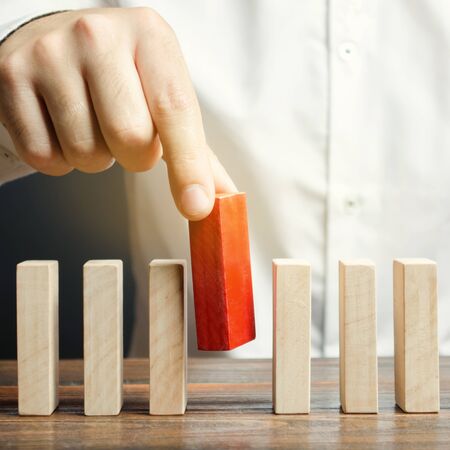 Businessman holds a wooden block in his hands. The concept of personnel selection and management within the team. Dismissal and hiring people to work. Human Resource Management. Leader selectionの写真素材