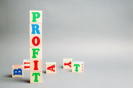 Wooden blocks with the word Profit and randomly scattered cubes. The financial result of the company for a certain period of time. Income. Return on investment. Performance. Profitable business.の写真素材