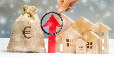 Miniature wooden house and up arrow with snowflakes. The concept of high housing demand. Investments for real estate in the winter. Mortgage interest rates. Expensive cost. Christmas marketの写真素材