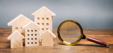 Magnifying glass and wooden houses. House searching concept. Home appraisal. Property valuation. Choice of location for the construction. Search for housing, apartments. Real estateの写真素材
