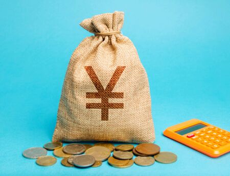 Money bag with coins and a calculator. Profit and finance concept. Budget, salary, income. Distribution of money and savings. Yen, yuanの写真素材