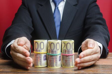 Businessman covers with hands euro money protection gesture. Provision money, credit, grant. Project...